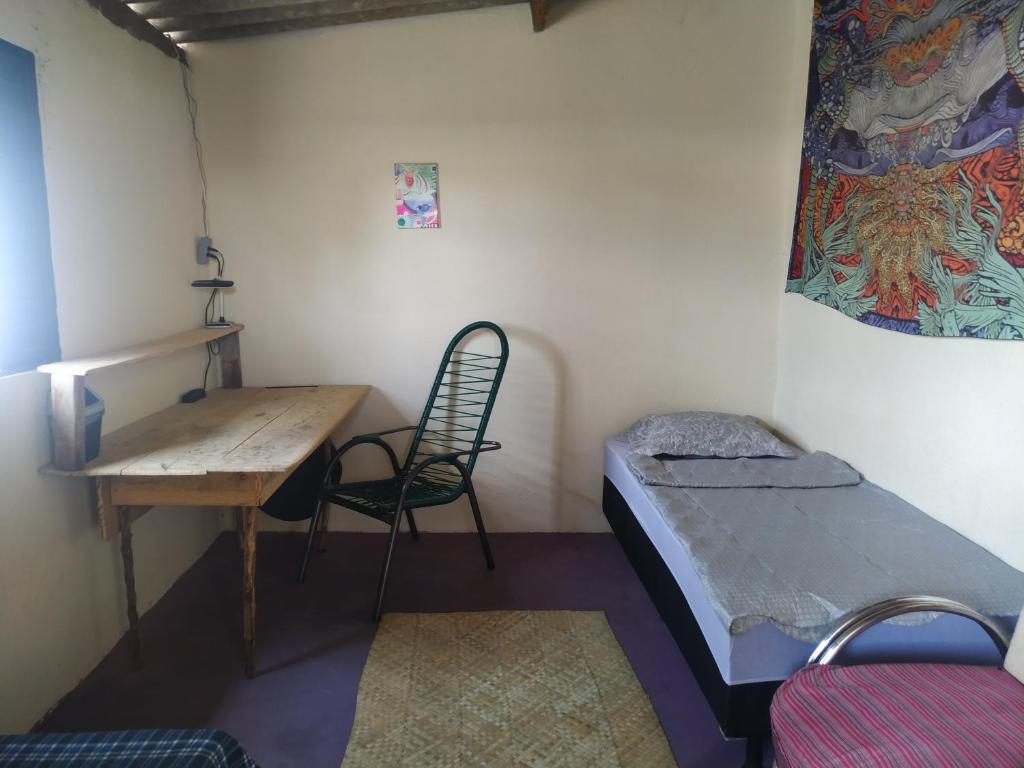 a room with a desk and a bed and a table at Casa Aloe Vera in Cavalcante
