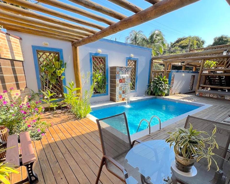 uma casa com uma piscina e um deque de madeira em VELINN Pousada Iguana Azul em Ilhabela