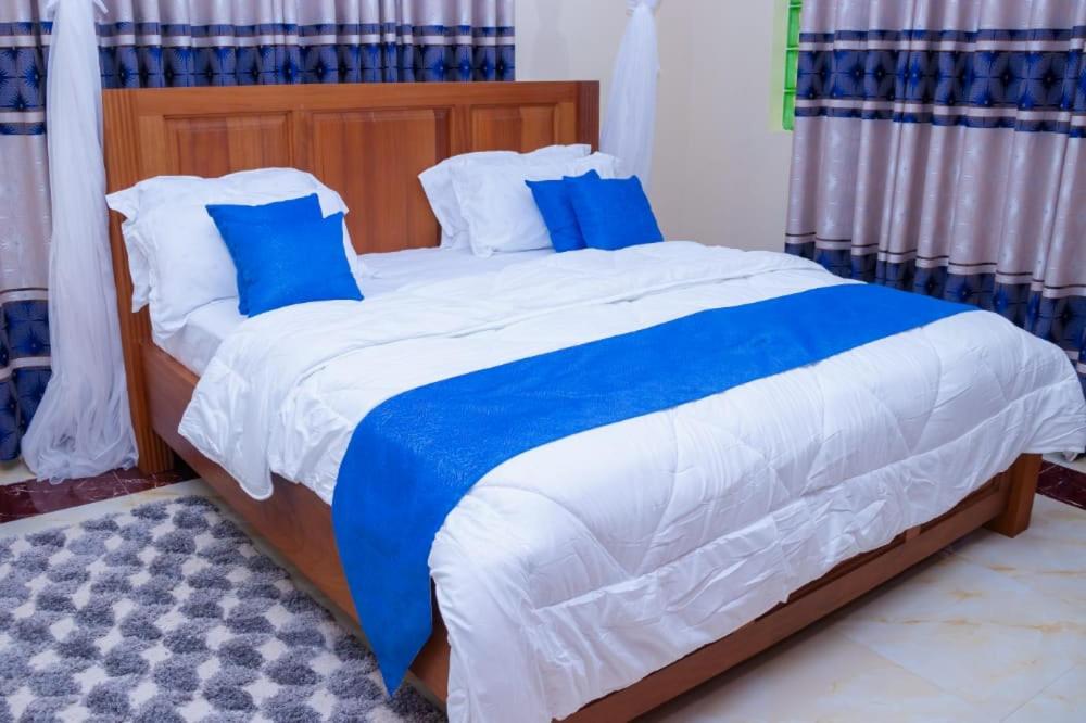 1 cama con sábanas azules y blancas y almohadas azules en 5 Bedroom Villa Near Pride Inn, en Mombasa