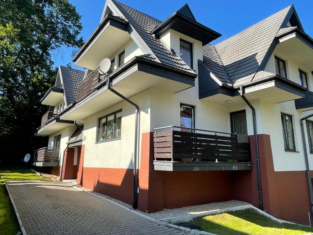 une maison avec un toit en gambrel dans l'établissement Apartament Idylla, à Zakopane