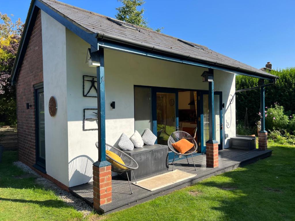een huis met een veranda met een bank en een stoel bij The Vikings Retreat in Donington on Bain