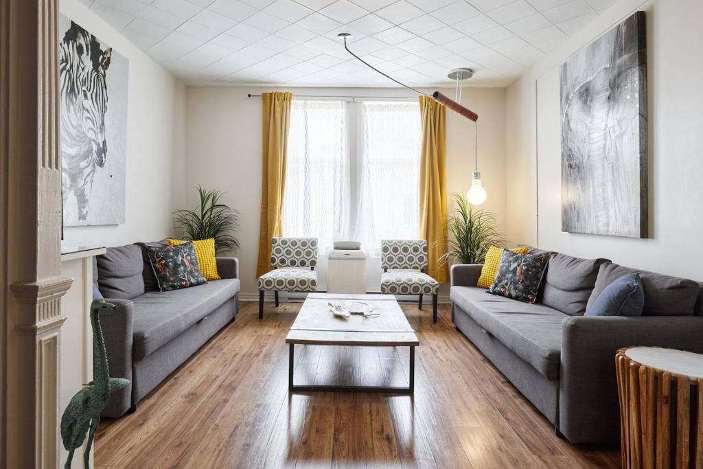 ein Wohnzimmer mit Sofas und einem Couchtisch in der Unterkunft MtlVacationRentals - MTL ZOO in Montreal