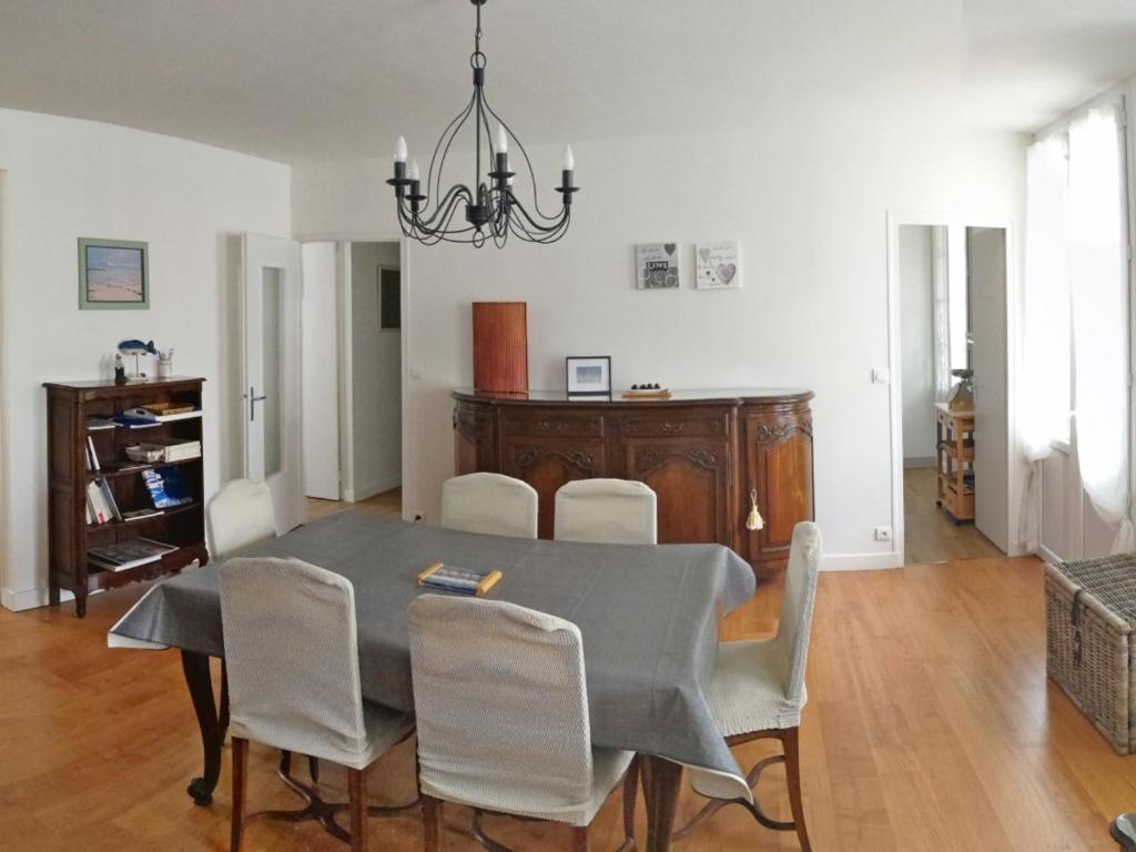 Appartement T3 confortable à Royan, proche plage et commerces - FR-1-71-51 في رويان: طاولة طعام مع كراسي وثريا