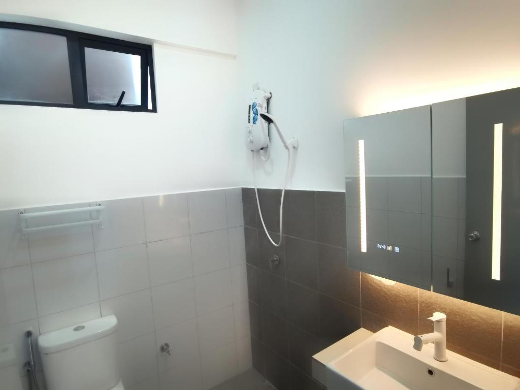 La salle de bains est pourvue d'une douche et d'un lavabo. dans l'établissement Super Comfort 2R2B Luxury Seaview Sandakan, à Sandakan