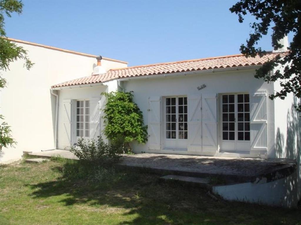 ein weißes Haus mit einer Veranda und einem Hof in der Unterkunft Maison La Tranche-sur-Mer, 3 pièces, 4 personnes - FR-1-22-214 in La Tranche-sur-Mer
