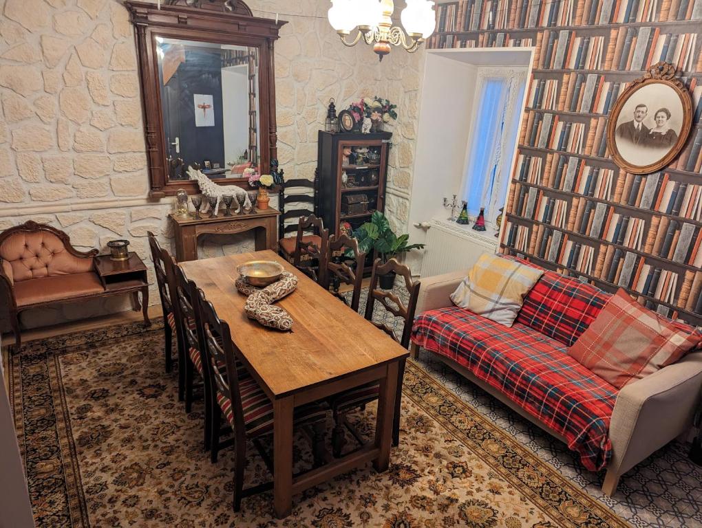 uma sala de estar com uma mesa e um sofá em La cachette sous l'escalier, le gîte ensorcelé 