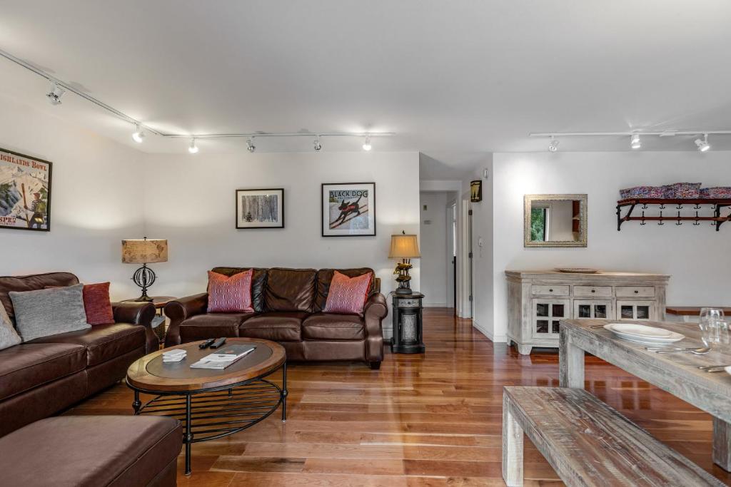 a living room with couches and a table at Woodbridge Condo by Snowmass Vacations in Snowmass Village