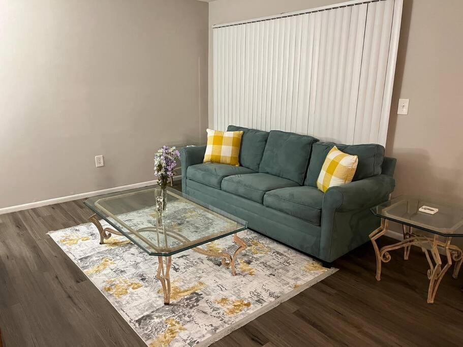 a living room with a green couch and a table at Cozy Retreat 1.8 Mi to Stadium in Gainesville