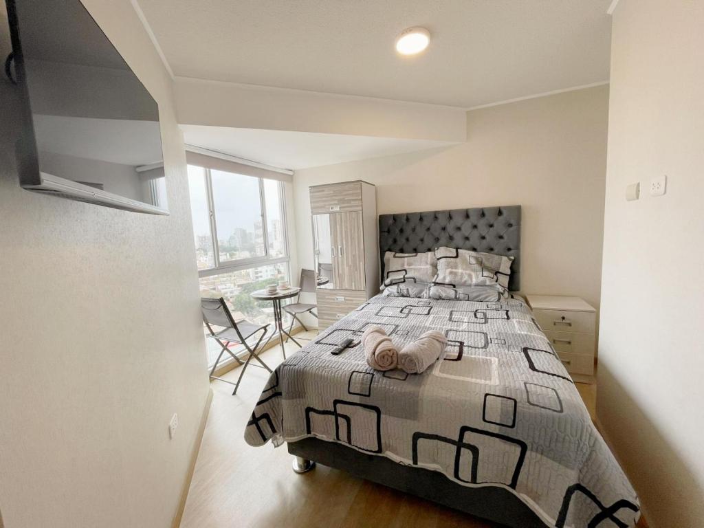 um quarto com uma cama grande num quarto com uma janela em Habitación privada con hermosa vista de Barranco em Lima