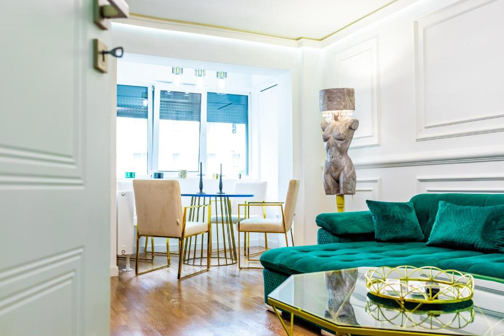 a living room with a green couch and a table at Lady Suite in Cluj-Napoca