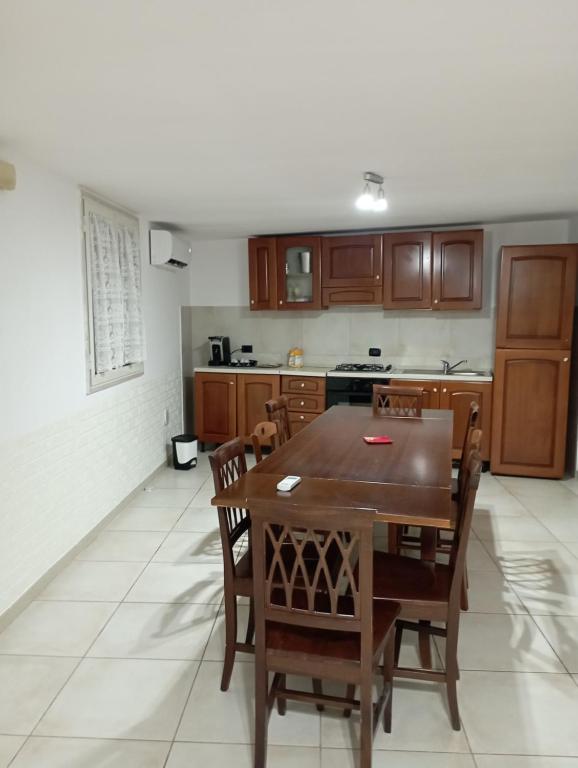 cocina con mesa de madera y sillas en DON BOSCO 2 en Bari Palese