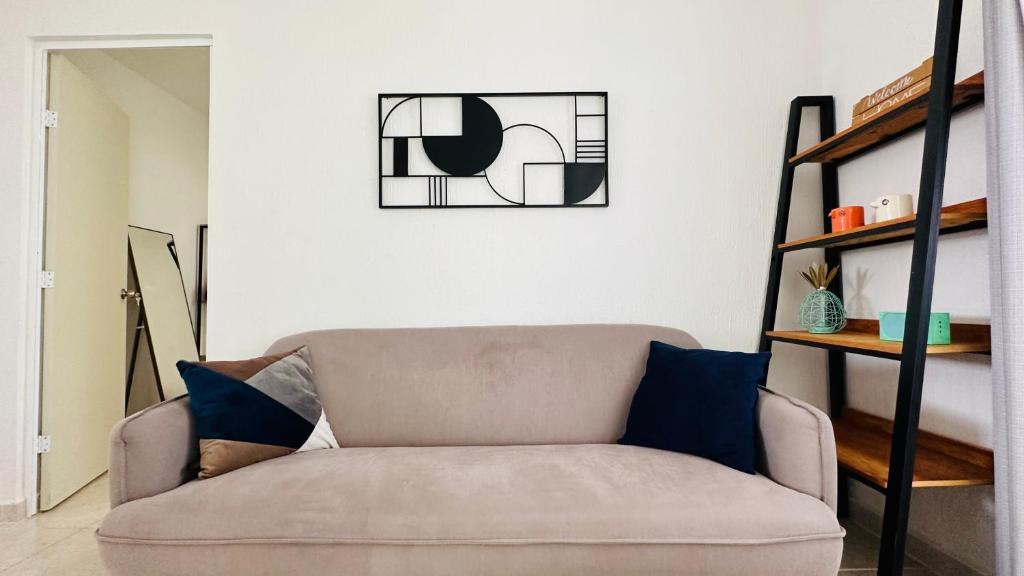 a living room with a couch and a shelf at Bonito departamento playa/planta baja in Playa del Carmen