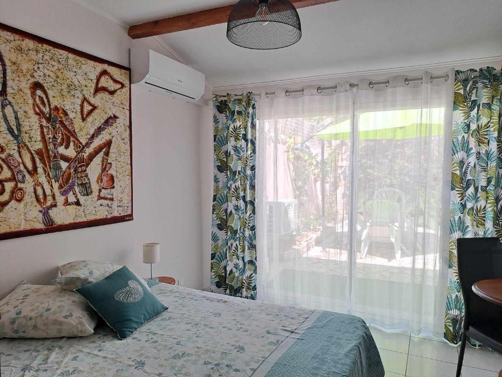 une chambre avec un lit et une grande fenêtre dans l'établissement Les Loulous, à Ceyreste