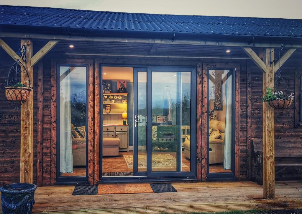 a screened in porch of a house with glass doors at The Lodge in Newton Stewart