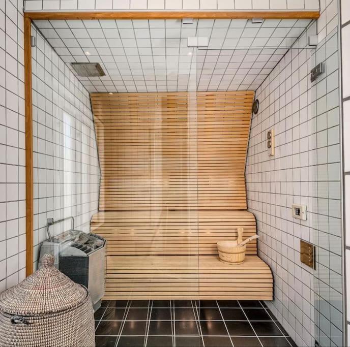 een grote houten douche in een badkamer met betegelde muren bij Central sommardröm Visby(AC,Jacuzzi, Bastu,Elbil) in Visby