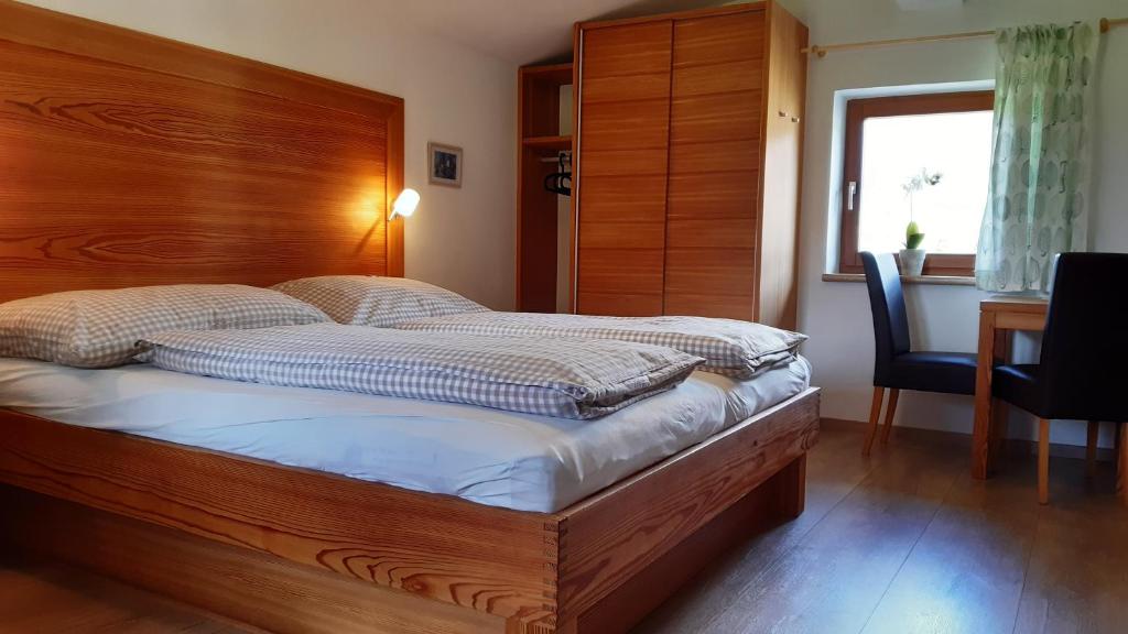 a bedroom with a bed with a wooden headboard at Doppelzimmer Herzogbauer in Saalfelden am Steinernen Meer
