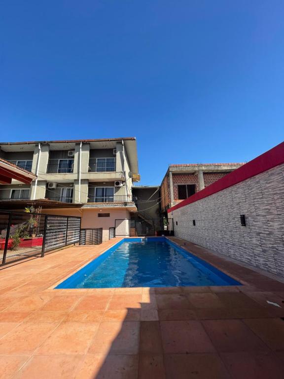 a swimming pool in front of a building at EL TATA APART in Puerto Iguazú