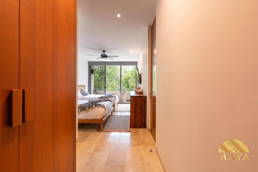 een hal die leidt naar een slaapkamer met een bed bij Exclusive condominium with pool in Tulum