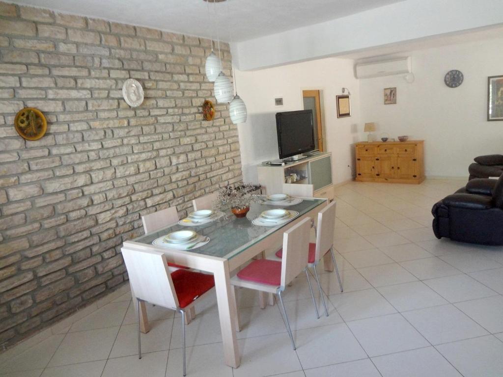 eine Küche und ein Wohnzimmer mit einem Tisch und Stühlen in der Unterkunft Villa Dijana in Prvić Šepurine