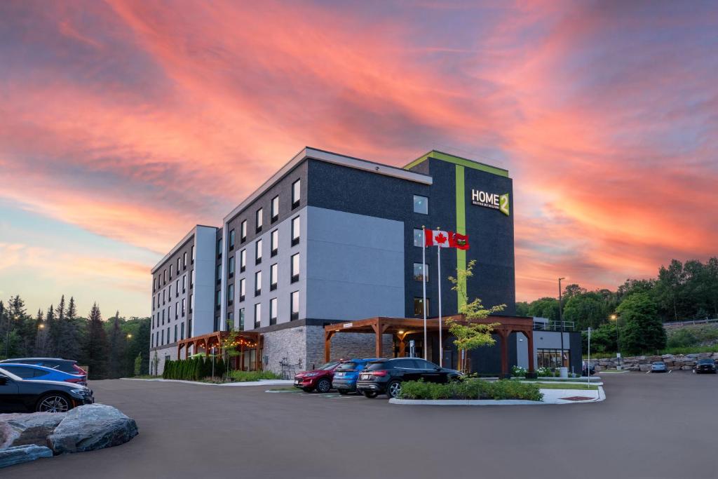 een hotel met auto's geparkeerd op een parkeerplaats bij Home2 Suites By Hilton Huntsville in Huntsville