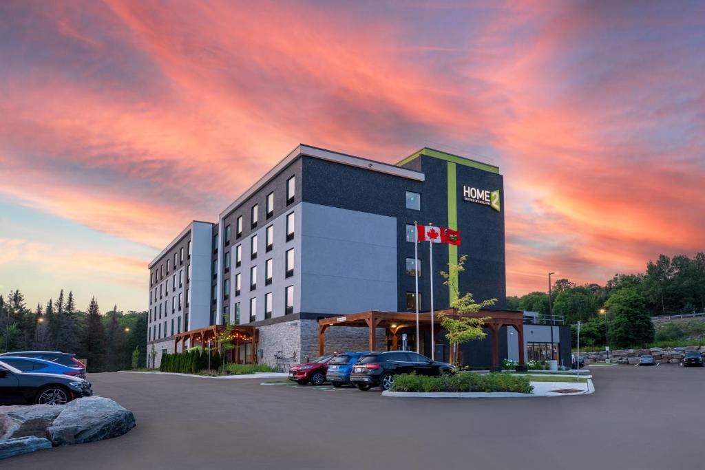 亨茨维尔Home2 Suites By Hilton Huntsville的停车场停着汽车的酒店