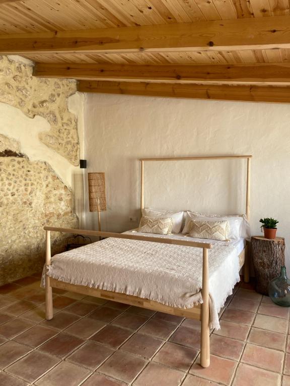 Cama en habitación con techo de madera en HOTEL ENOTURISMO MAINETES, en Fuente Álamo