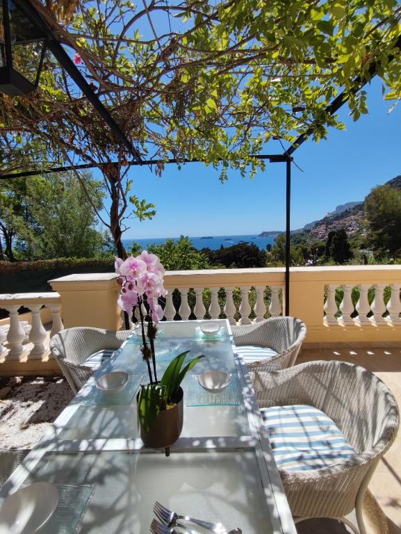 - une table avec un vase de fleurs sur la terrasse dans l'établissement MAISON AVEC SPLENDIDE VUE MER et MONACO 5 minutes des PLAGES, à Roquebrune-Cap-Martin