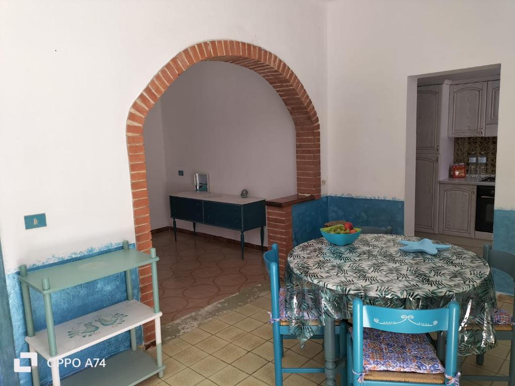 a room with a table and a kitchen with an archway at Casa vacanze sa Cresiedda in Iglesias