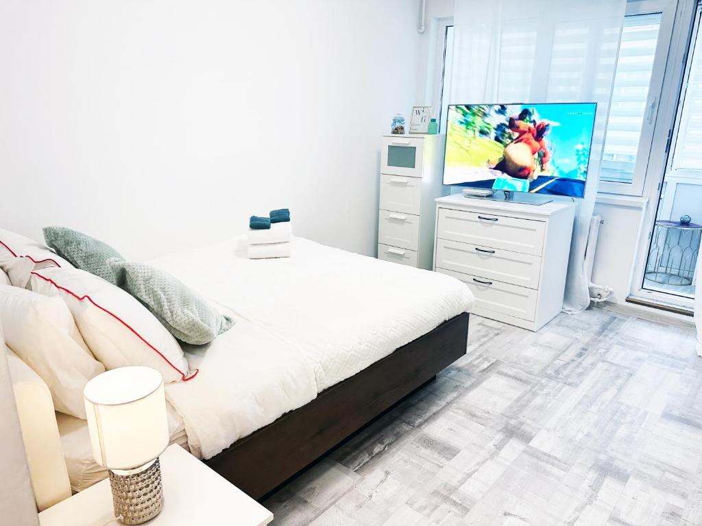 a bedroom with a bed and a television on a dresser at VICTORIEI STUDIO - PARC KISELEFF in Bucharest