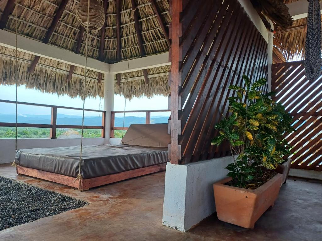 1 dormitorio con 1 cama en una habitación con techo de paja en Sunset Beachside Villa, en Puerto Escondido