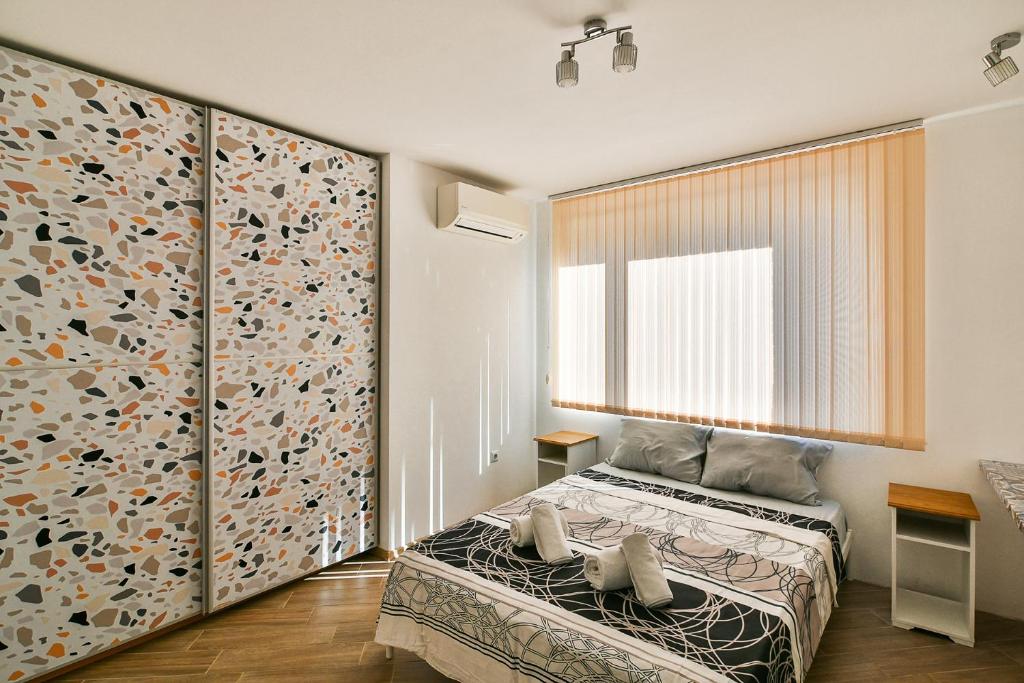 Un dormitorio con una cama y una ventana grande. en Central flat Wi-Fi & streaming, en Varna