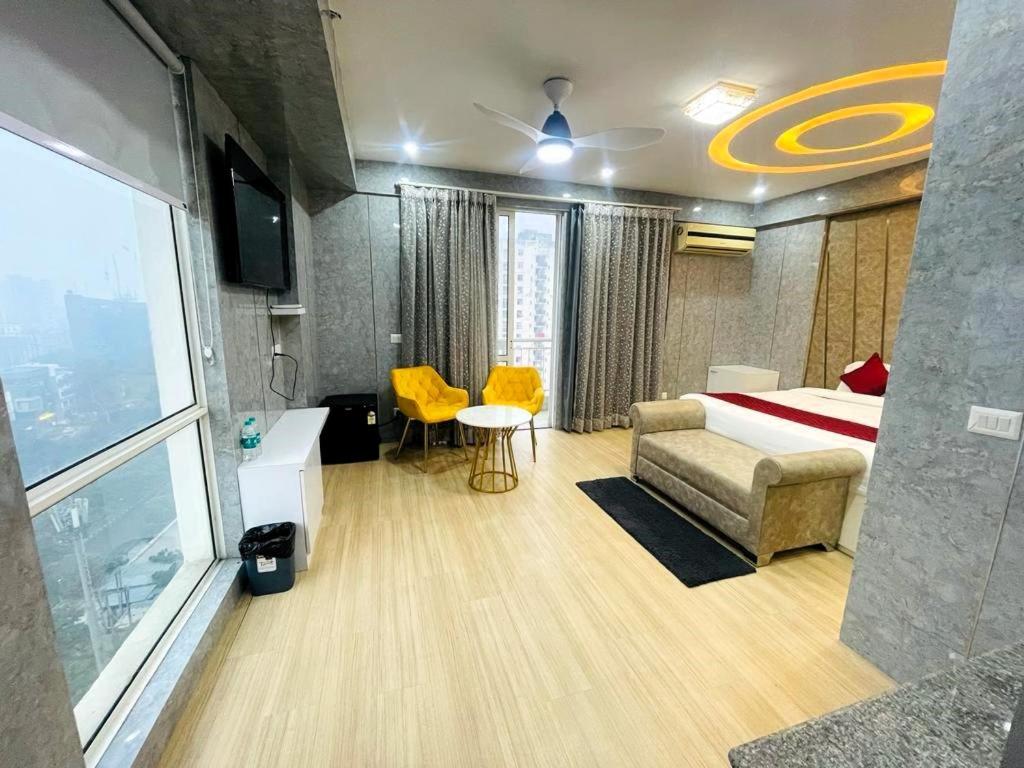 勒克瑙的住宿－Golden Penthouse - Couple Friendly - DLF My pad, Gomtinagar, Lucknow，一间卧室配有一张床、一张桌子和黄色的椅子