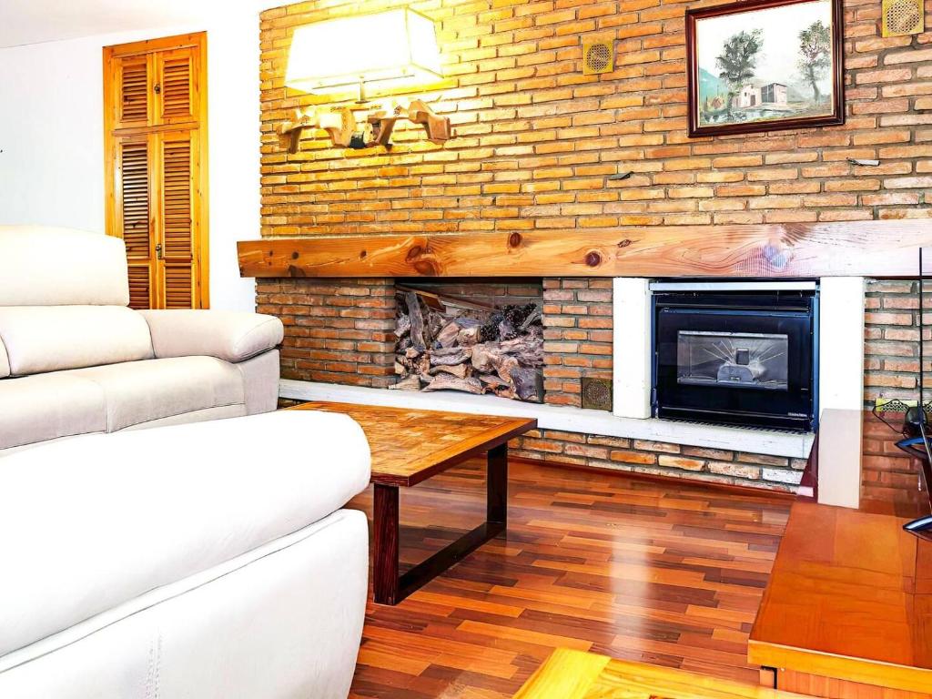 a living room with a fireplace and a table at Apartamento Deluxe zona Baja con Garaje in Sierra Nevada