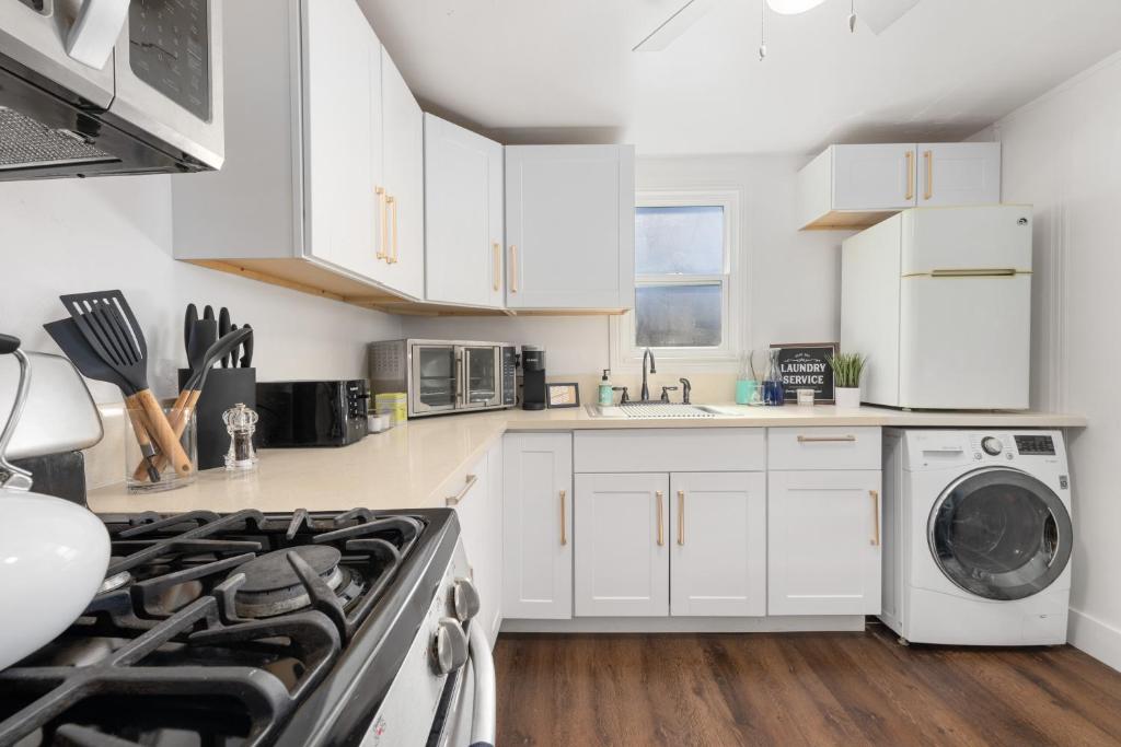 a kitchen with white cabinets and a washer and dryer at Cozy 1bdr/1br home near downtown in Sacramento