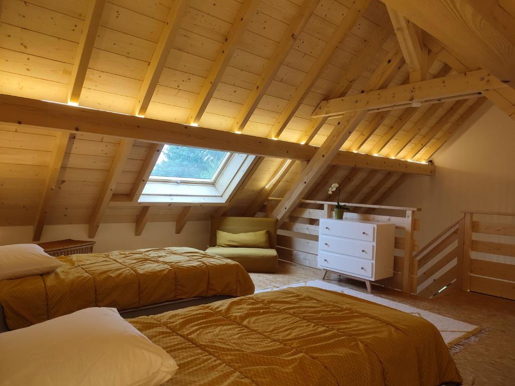 SigolsheimにあるAlsace Chalet & Spa Meyer-Krumbのベッド2台と窓が備わる屋根裏部屋です。