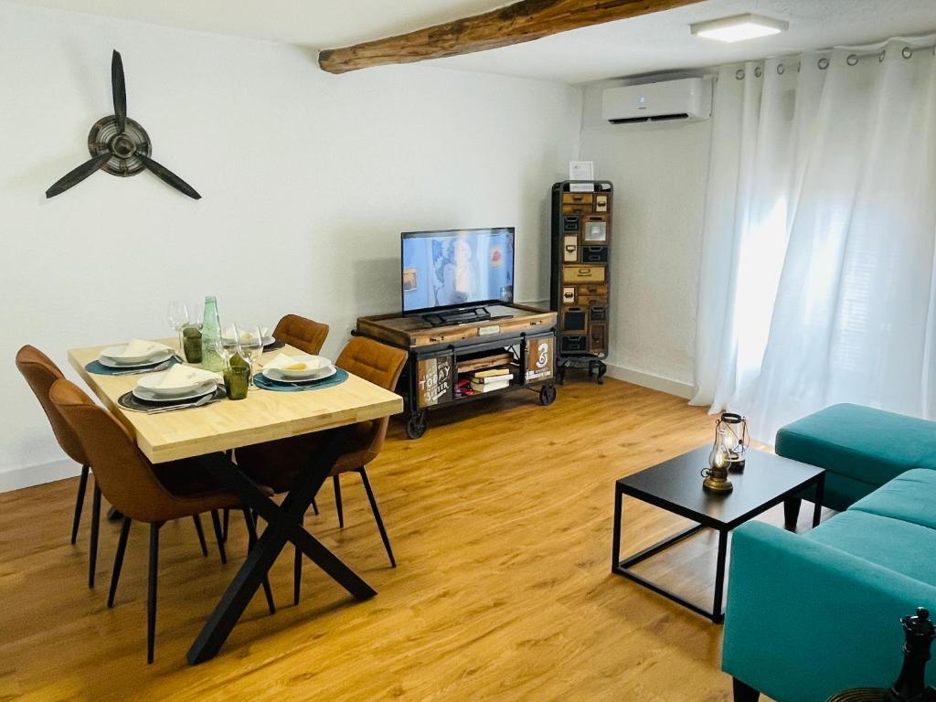 a living room with a table and a tv at Alojamiento Singular Casa Haraiz in Jaraiz de la Vera