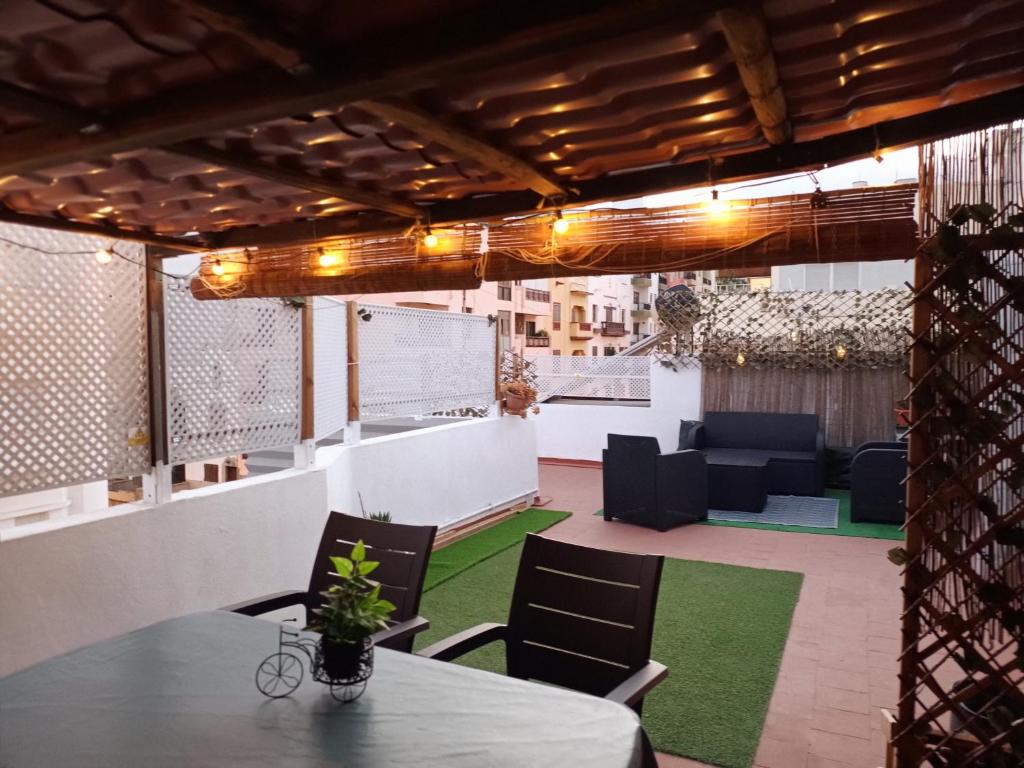 eine Terrasse mit einem Tisch, Stühlen und einem Sofa in der Unterkunft CENTER Santa Cruz, Alojamiento céntrico con gran terraza, cocina , salón y baños, todo privado in Santa Cruz de Tenerife