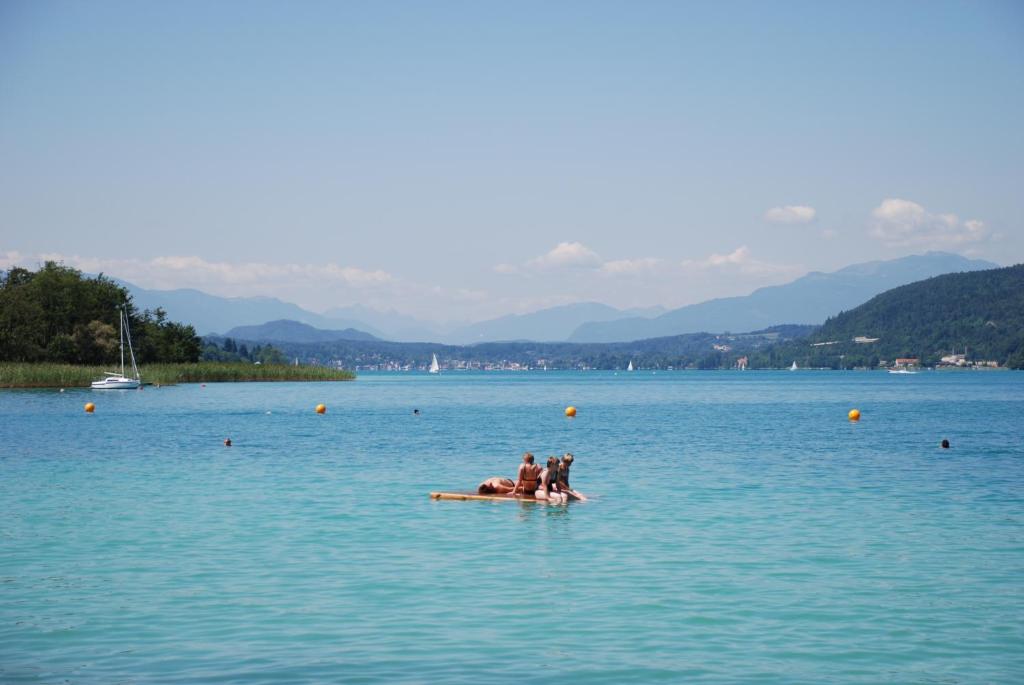 a group of people sitting on a raft in the water at Gasthof Thomann in Velden am Wörthersee
