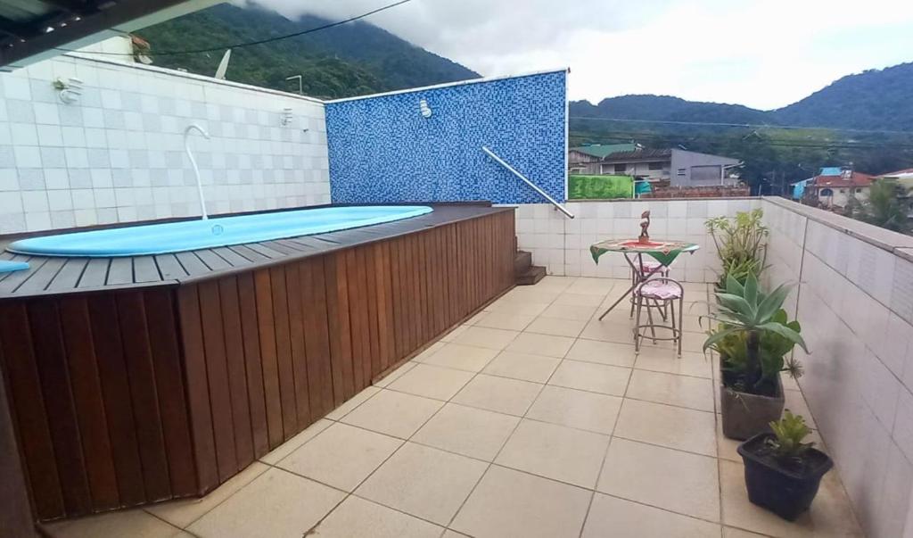 uma varanda com uma banheira de hidromassagem e uma mesa no telhado em Casa com Belas vistas - Muriqui em Mangaratiba