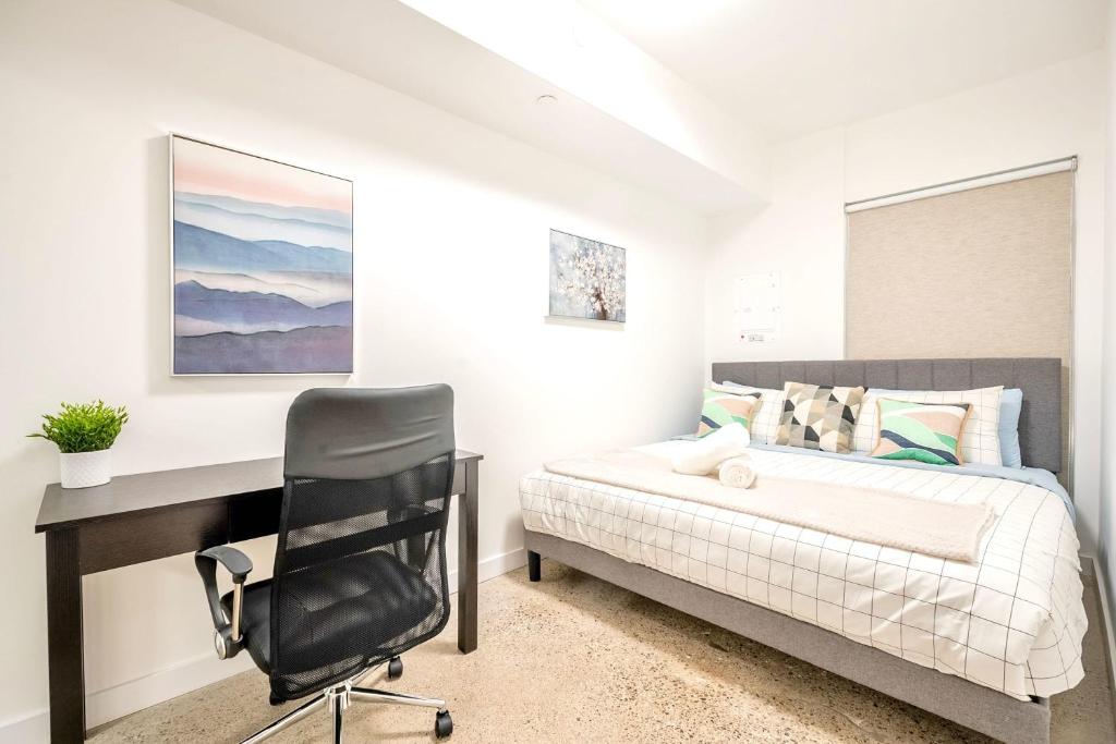1 dormitorio con escritorio, 1 cama y 1 silla en Spacious 2BR Apartment - Stunning View of CN Tower, en Toronto