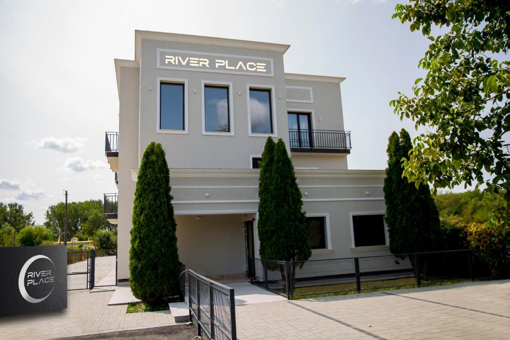 a white building with a sign that reads river place at RIVER PLACE in Piteşti