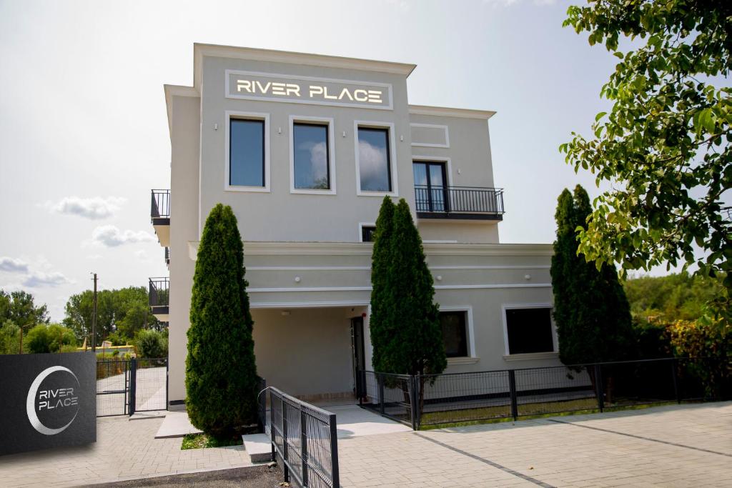 Biały budynek z napisem "River Place" w obiekcie RIVER PLACE w Piteszti