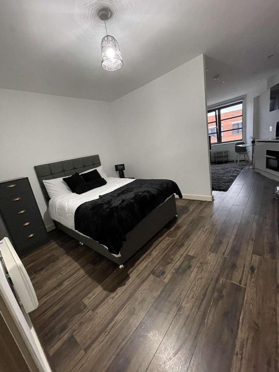 um quarto com uma cama grande e piso em madeira em One Bedroom Apartment/Studio em Birmingham