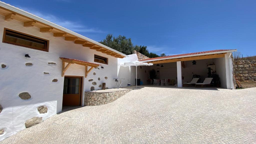 a large white house with a large patio at Casa de Alcaria in Alcaria