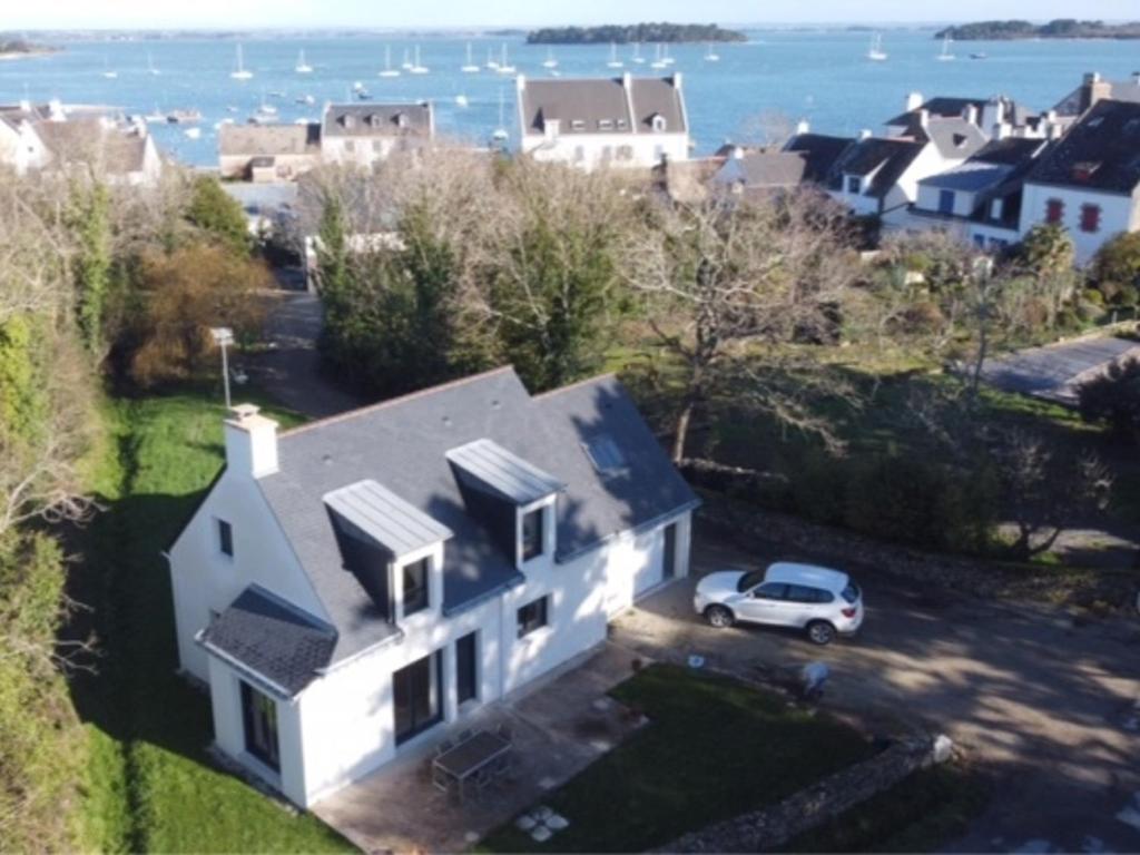 une maison blanche avec une voiture garée devant elle dans l'établissement Maison familiale - 8 pers - Proche mer et port - Jardin et terrasse - FR-1-639-40, à Sarzeau
