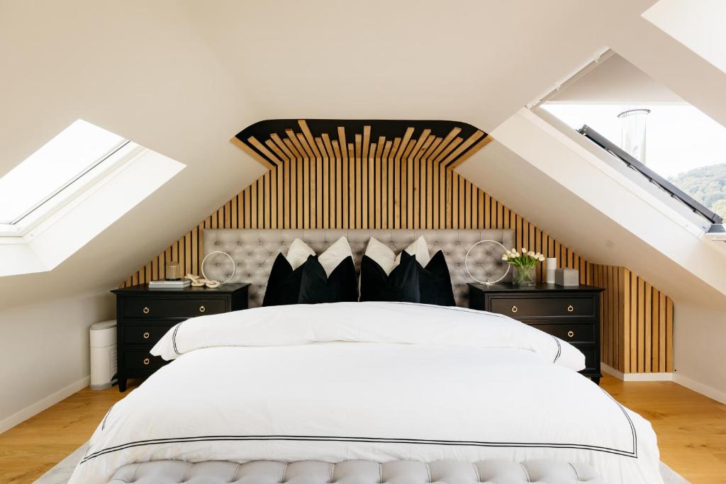- une chambre avec un grand lit blanc et des lucarnes dans l'établissement The Edgewater Suites - RIVERSIDE, à Namur
