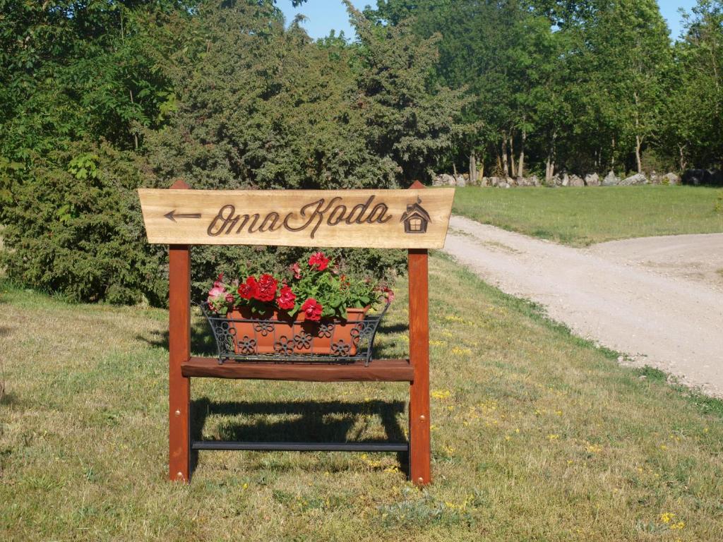 a sign for a garden with flowers in a field at Omakoda in Vanamõisa