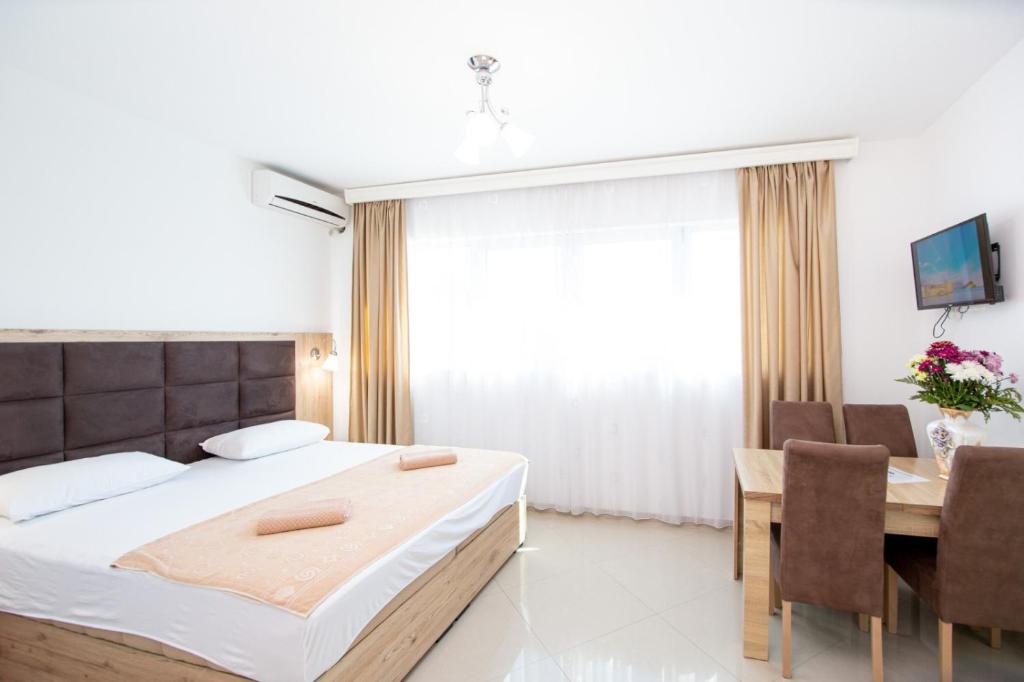 um quarto com uma cama, uma mesa e cadeiras em Apartments Blanco em Budva