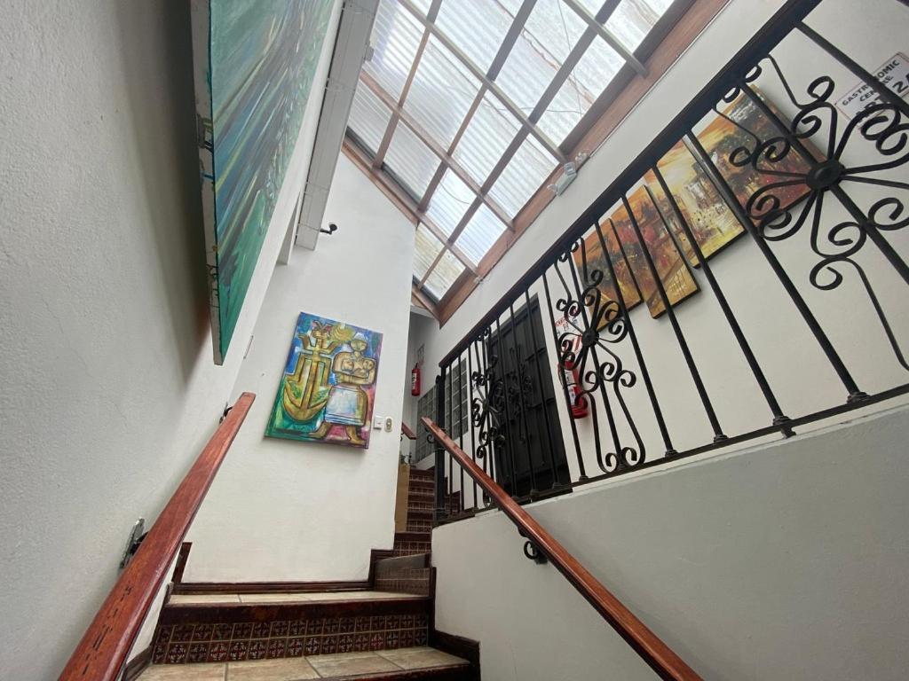 a hallway with stairs with a painting on the wall at Sofia Apartments in Escalante, San Jose Center in San José