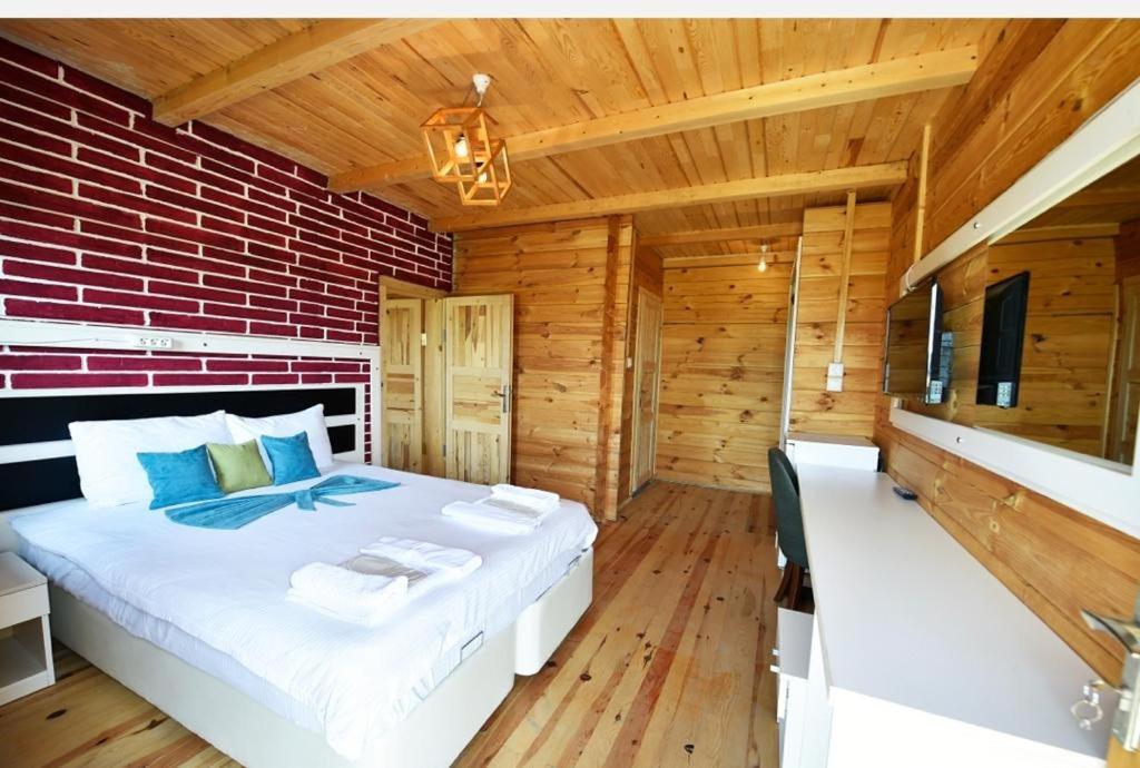 a bedroom with a large bed in a wooden room at disharoyaylaevleri in Meşeli